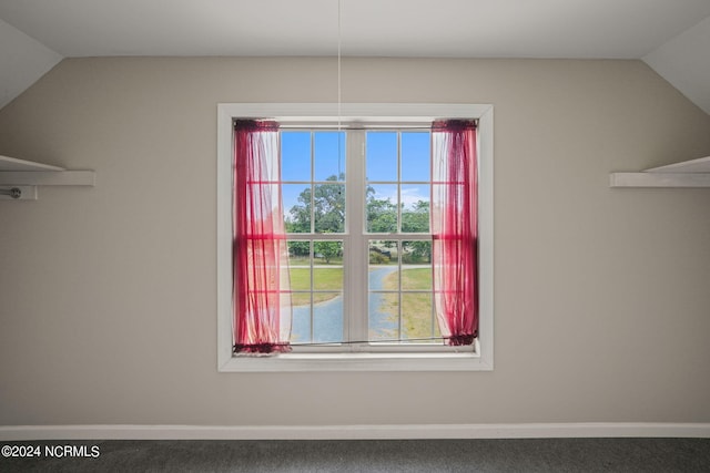 unfurnished dining area featuring vaulted ceiling and carpet