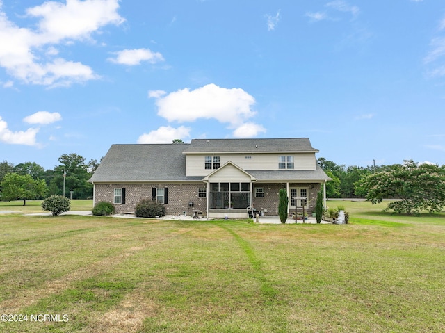 back of house featuring a patio, a sunroom, and a lawn