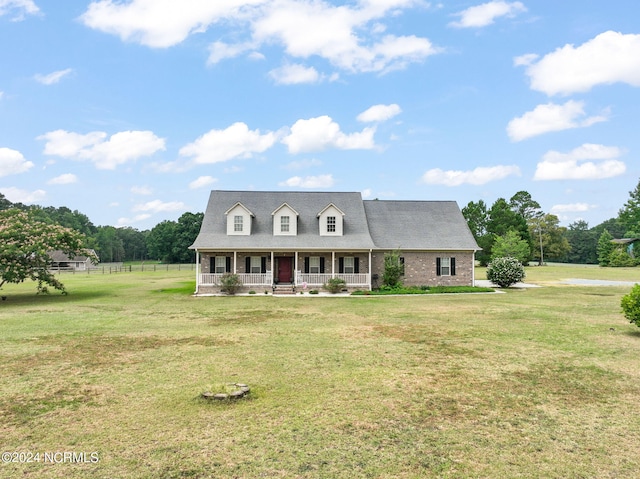 cape cod house featuring a front yard and covered porch