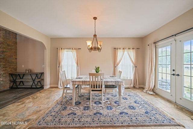 dining space with french doors and a notable chandelier