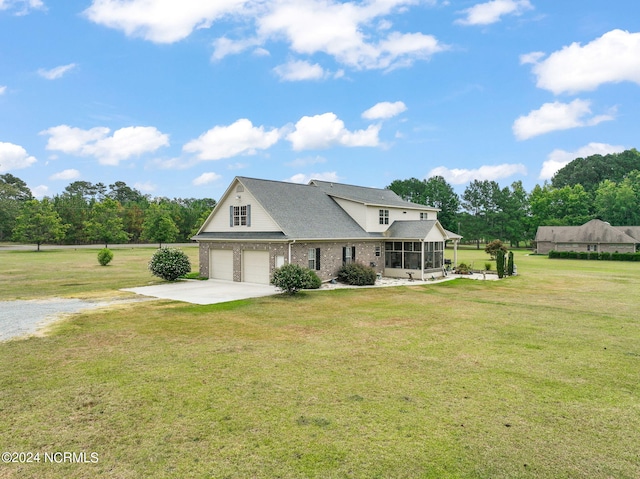 view of front of house with a garage, a sunroom, and a front lawn