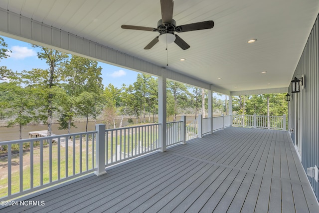 wooden terrace with ceiling fan and a lawn