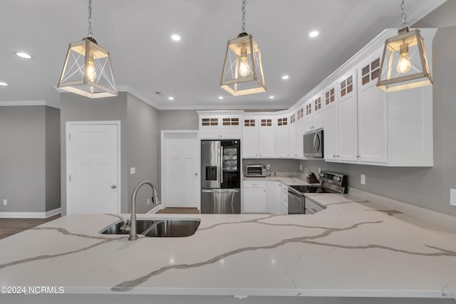 kitchen with hanging light fixtures, stainless steel appliances, sink, and light stone countertops