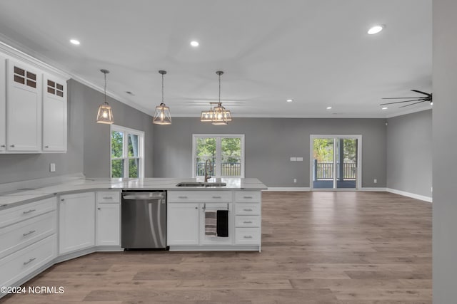 kitchen with a wealth of natural light, sink, white cabinets, ornamental molding, and stainless steel dishwasher