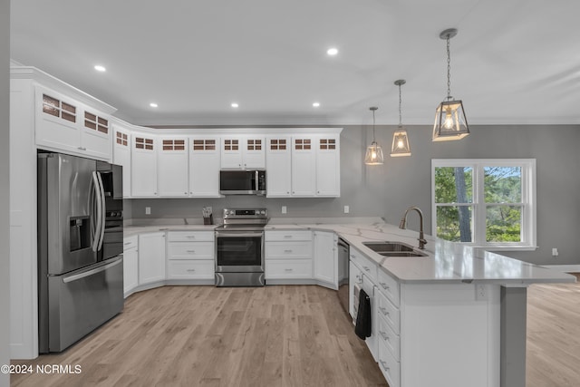 kitchen with white cabinetry, appliances with stainless steel finishes, pendant lighting, and kitchen peninsula