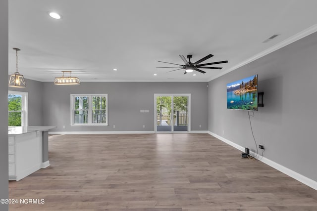 unfurnished living room with crown molding, plenty of natural light, and light wood-type flooring