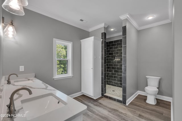 bathroom featuring crown molding, tiled shower, hardwood / wood-style floors, and vanity