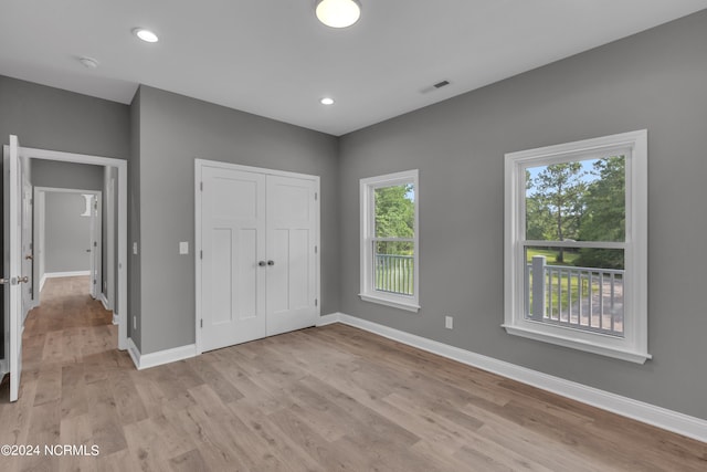 unfurnished bedroom featuring light hardwood / wood-style flooring and a closet