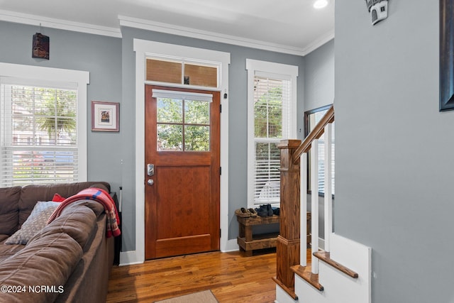 entryway with hardwood / wood-style flooring and ornamental molding