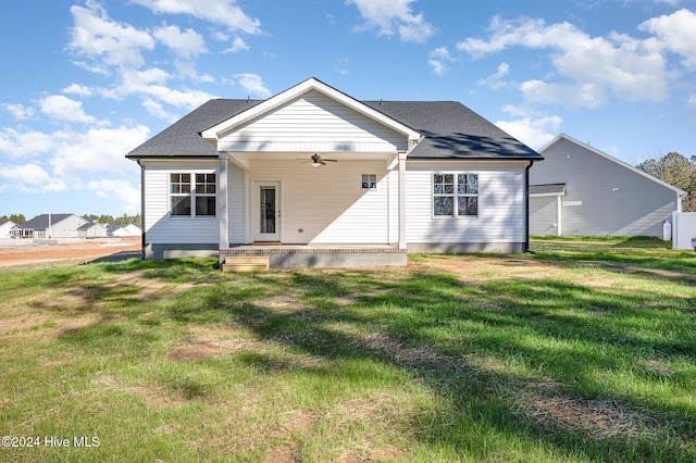 back of house with a lawn and ceiling fan