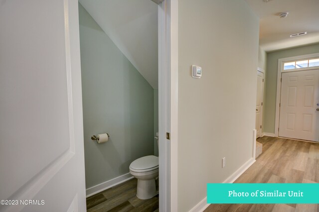 unfurnished living room with sink, light hardwood / wood-style floors, and an inviting chandelier