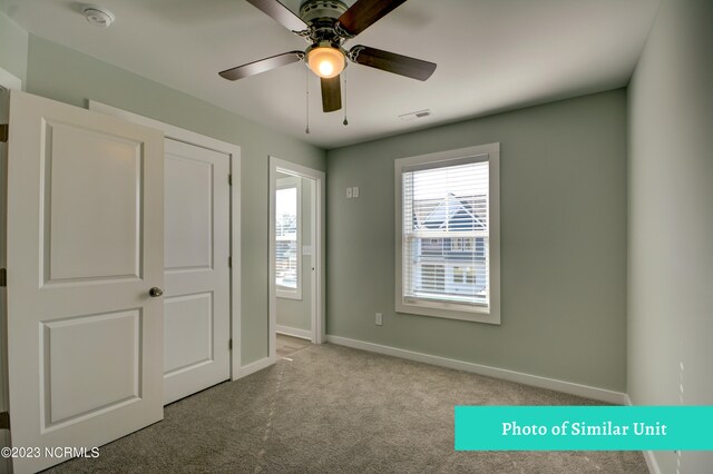 carpeted empty room featuring ceiling fan