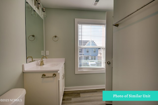 bathroom featuring hardwood / wood-style floors, vanity, and toilet