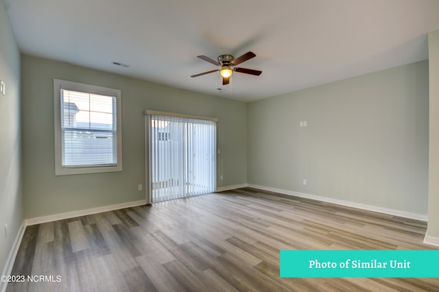 empty room with hardwood / wood-style floors and ceiling fan