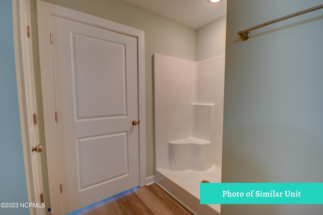 bathroom with hardwood / wood-style floors and walk in shower