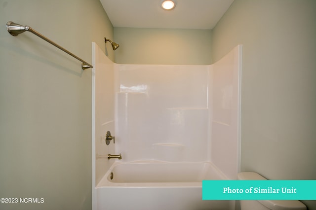 bathroom with bathing tub / shower combination and toilet