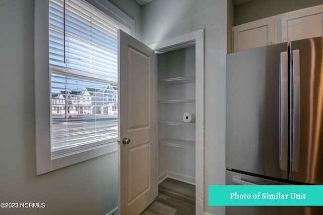 kitchen with dark hardwood / wood-style flooring and stainless steel refrigerator