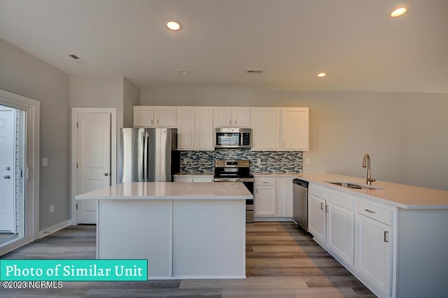 kitchen featuring white cabinetry, a center island, stainless steel appliances, and sink