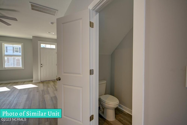 bathroom featuring ceiling fan, toilet, vaulted ceiling, and hardwood / wood-style flooring