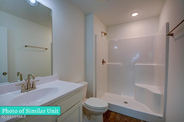 bathroom with vanity, toilet, and a shower