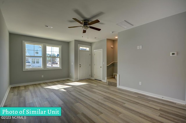 foyer entrance with ceiling fan and light wood-type flooring