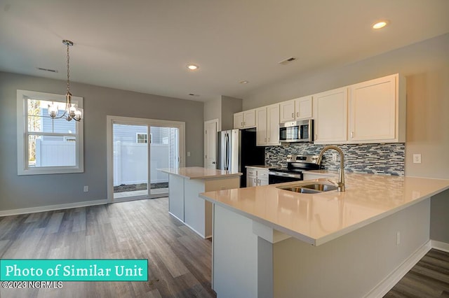 kitchen with kitchen peninsula, a chandelier, sink, and stainless steel appliances