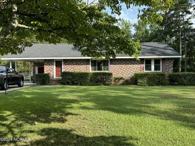 ranch-style house featuring a carport and a front yard