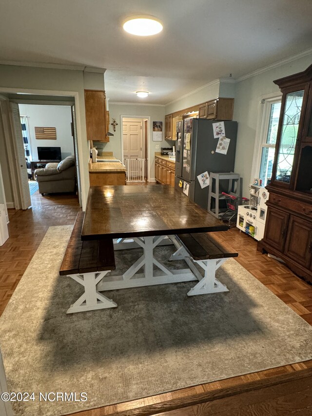 kitchen with stainless steel fridge, ornamental molding, and dark parquet flooring