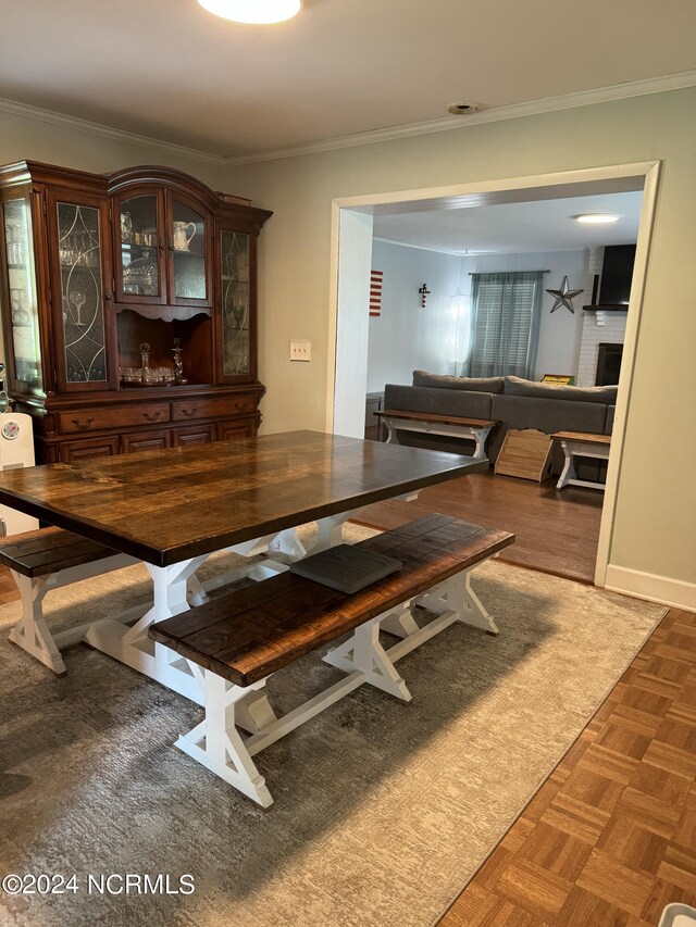 dining space featuring crown molding and dark parquet floors