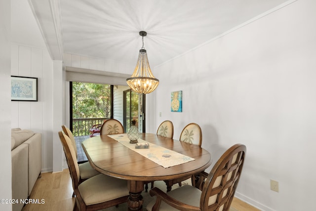 dining area featuring crown molding, light hardwood / wood-style flooring, and a notable chandelier