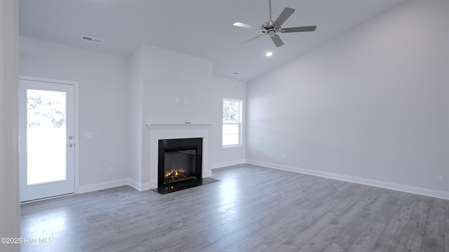 1254 Palatka Pl SE, Bolivia, NC 28422 - unfurnished living room featuring wood finished floors, a lit fireplace, baseboards, high vaulted ceiling, and recessed lighting