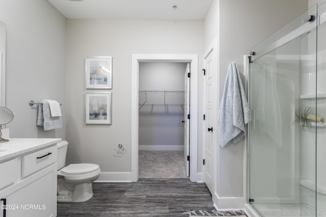 bathroom featuring vanity, hardwood / wood-style floors, toilet, and walk in shower