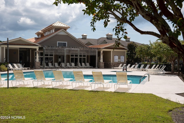 view of swimming pool featuring a patio, a pergola, and a lawn