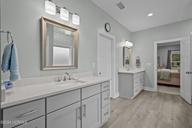 bathroom with dual vanity and hardwood / wood-style floors