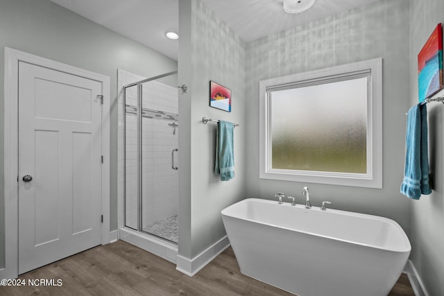 bathroom featuring hardwood / wood-style floors and separate shower and tub