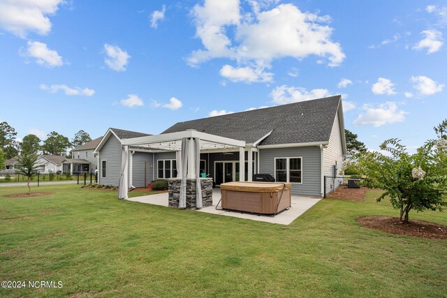 back of house with a pergola, a patio, a yard, and a hot tub