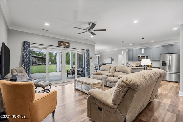 living room featuring ornamental molding, light hardwood / wood-style flooring, ceiling fan, and french doors