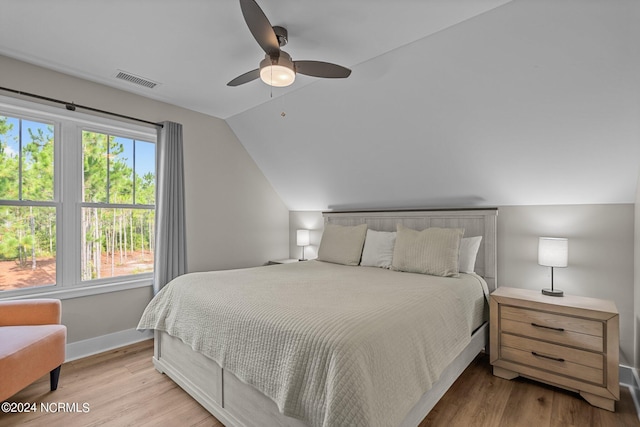 bedroom featuring vaulted ceiling, multiple windows, ceiling fan, and light wood-type flooring