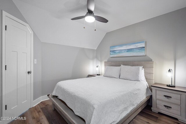 bedroom featuring dark wood-type flooring, vaulted ceiling, and ceiling fan