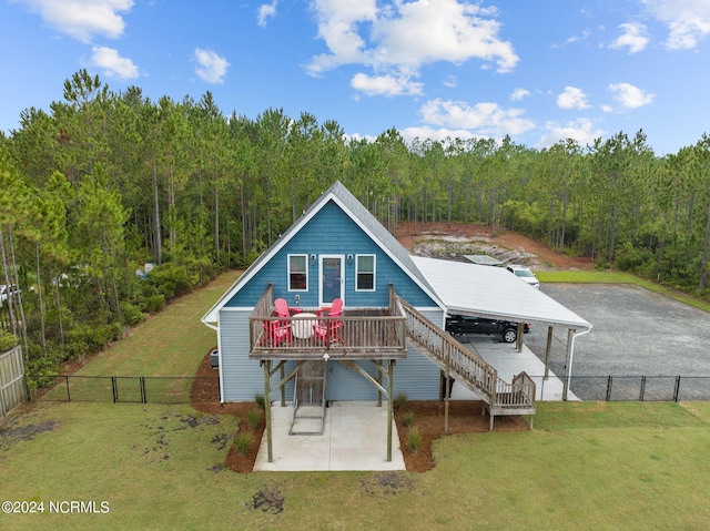 rear view of house with a wooden deck and a yard