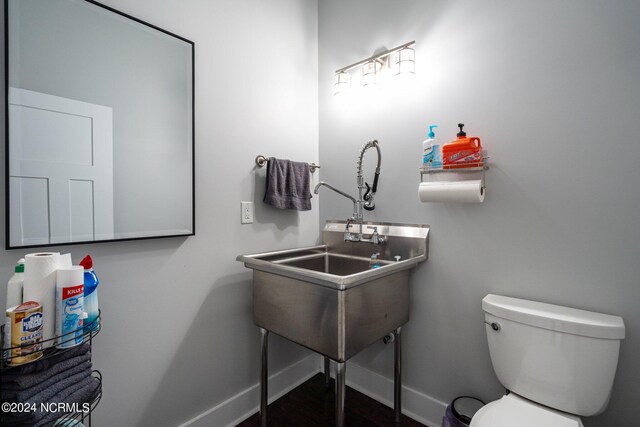 bathroom with hardwood / wood-style flooring and toilet