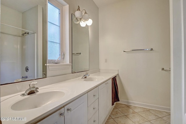 bathroom with plenty of natural light, tile patterned flooring, vanity, and a shower