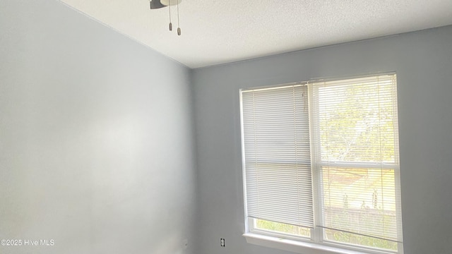 spare room with ceiling fan and a textured ceiling