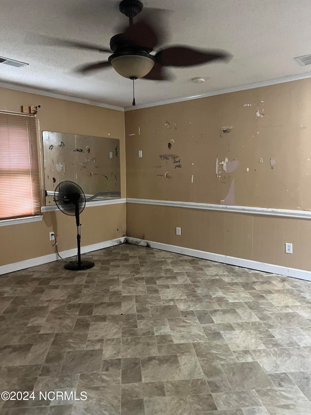 spare room with ceiling fan, a textured ceiling, and crown molding