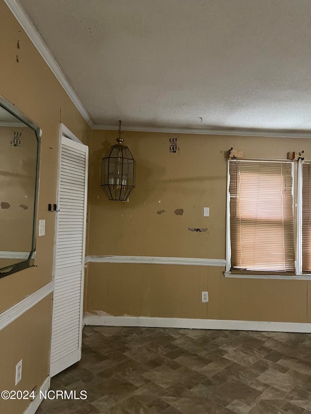 spare room featuring a textured ceiling and ornamental molding