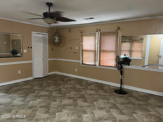 empty room featuring a textured ceiling, ceiling fan, and ornamental molding