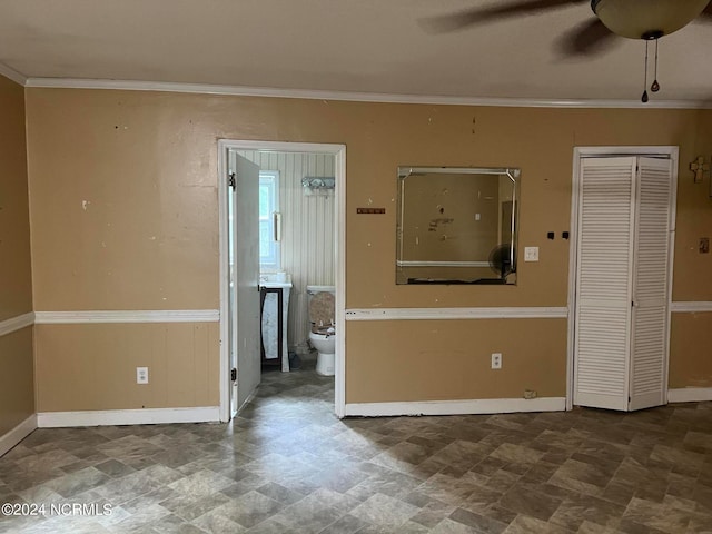 unfurnished room with ceiling fan and crown molding