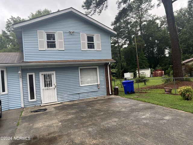 view of front of home with a front yard and a shed