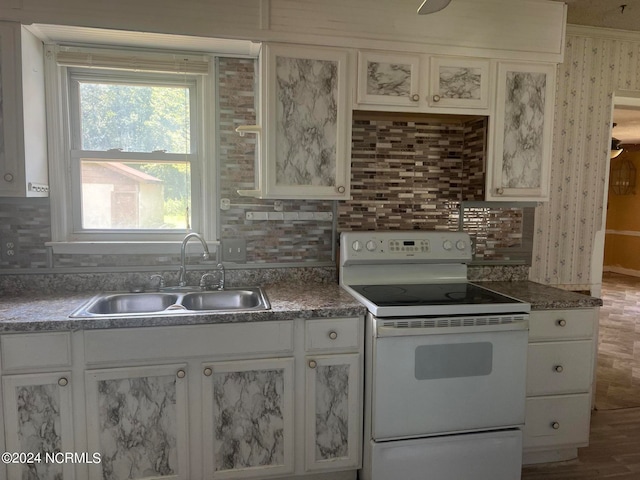 kitchen with sink, electric range, decorative backsplash, and white cabinetry