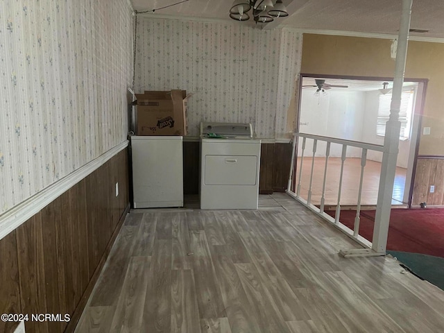 clothes washing area with ceiling fan, crown molding, washing machine and dryer, and light wood-type flooring